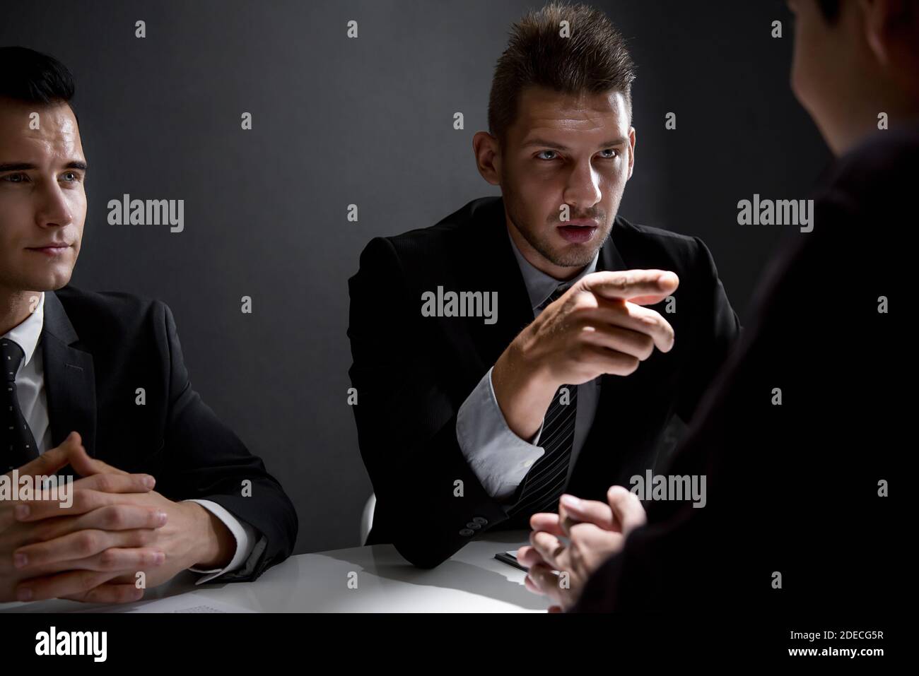 Detektive interviewen Verdächtigen oder kriminellen Mann im Verhörraum Stockfoto