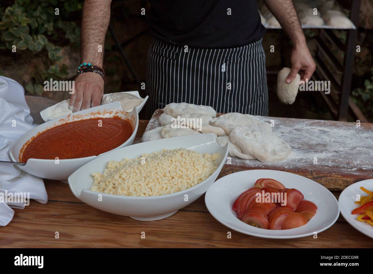 Vorbereiten und Backen einer Focaccia Pizza mit Tomatenmark und Käse Stockfoto