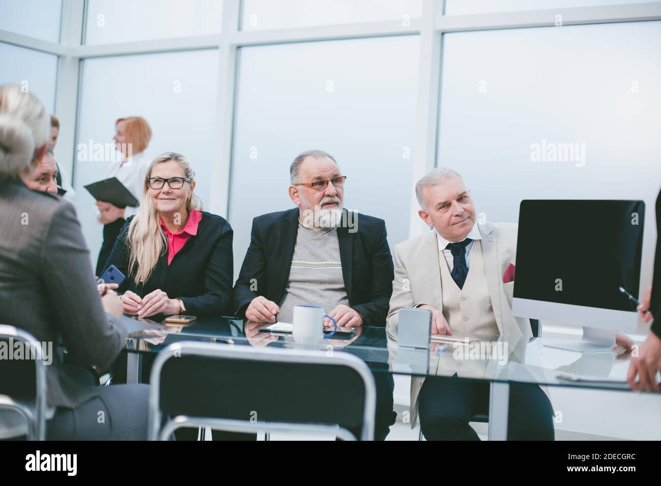Gruppe von Geschäftsleuten, die im Konferenzraum von sitzen Der Verhandlungstisch Stockfoto