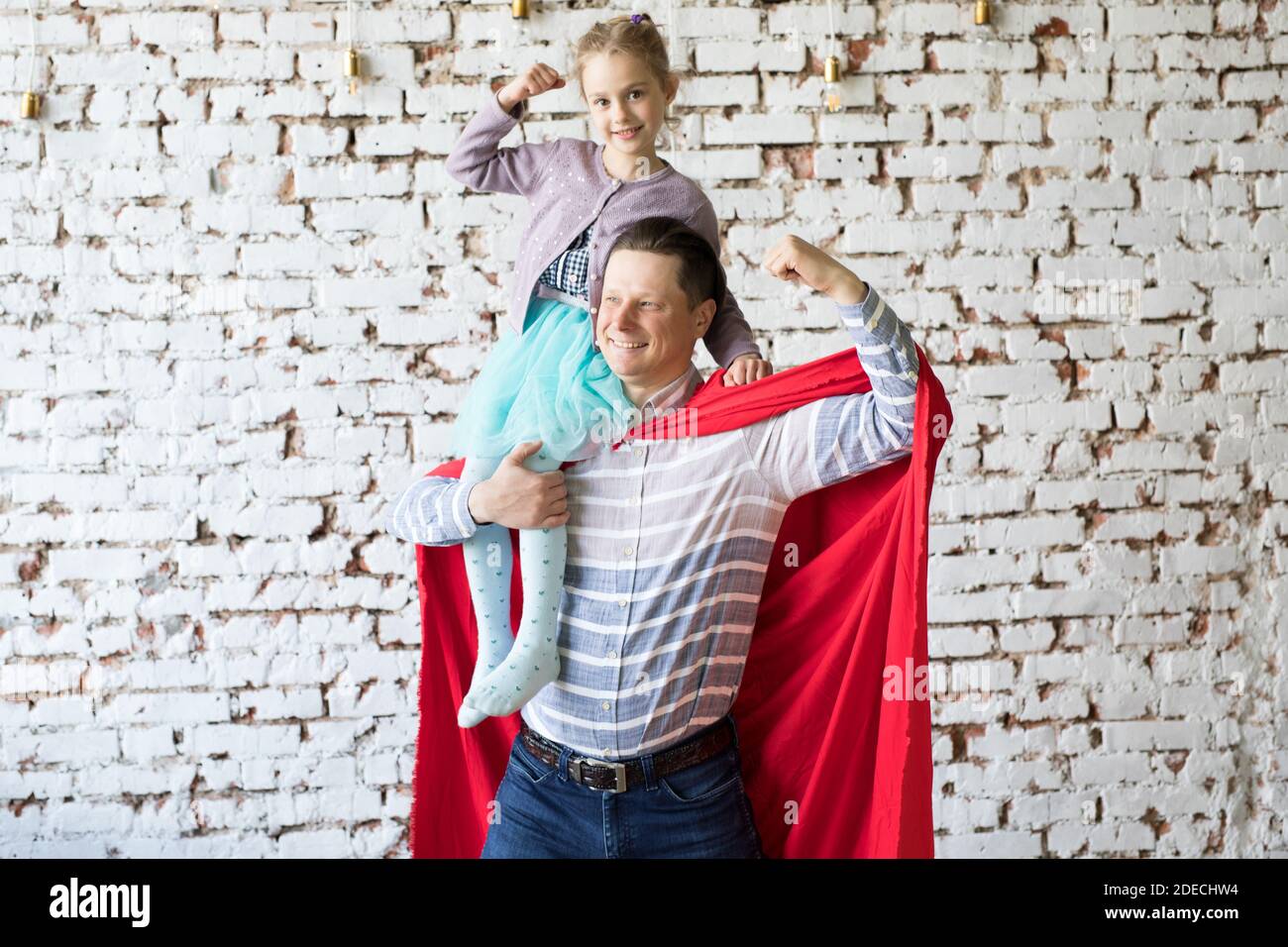 Glücklicher Vater in Superhelden-Kostüm und seine Tochter Stockfoto