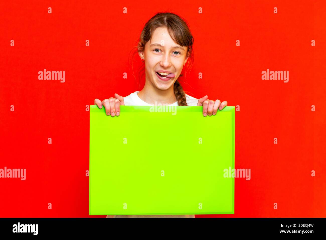 Junge selbstzufrieden kaukasischen Teenager Mädchen mit leerem Papier Blatt über roten Studio Hintergrund. Stockfoto