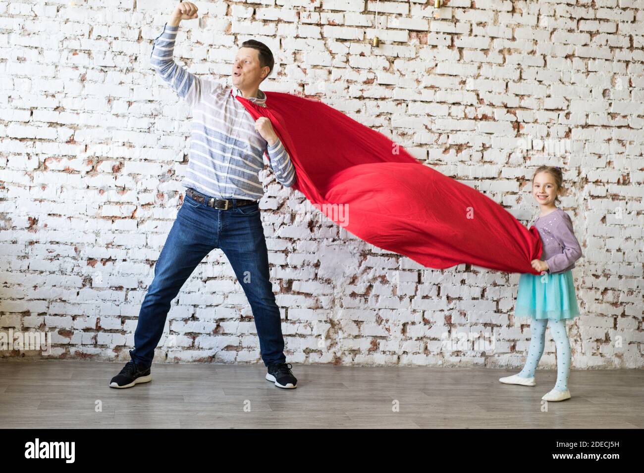 Glücklicher Vater in Superhelden-Kostüm und seine Tochter Stockfoto