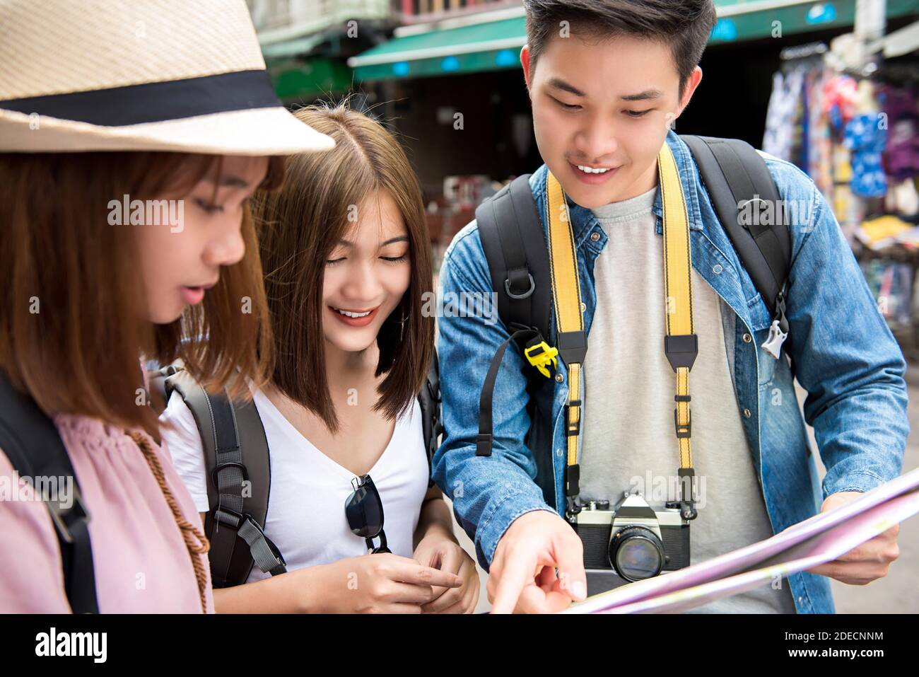 Eine Gruppe junger asiatischer Touristen-Backpacker-Freunde, die auf der Karte Richtung suchen, während sie in Khao San Road, Bangkok, Thailand reisen Stockfoto