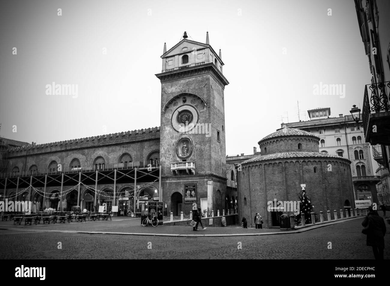 Mantua, Lombardei, Italien, Dezember 2015: Der Uhrturm und die Kirche der Rotonda San Lorenzo in Piazza delle Erbe, während der Weihnachtszeit. Schwarzweiß-Fotografie. Stockfoto