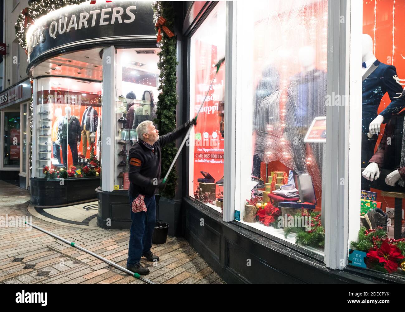 Cork City, Cork, Irland. November 2020. Rory O’Donovan aus Kileens putzt die Fenster des Herrenladens Gentleman’s Quarters in Patrick’s Street, Cork, in Vorbereitung auf die Wiedereröffnung der Geschäfte am 1. Dezember, wenn das Land eine sechswöchige Stufe 5-Sperre beendet. - Credit; David Creedon / Alamy Live News Stockfoto