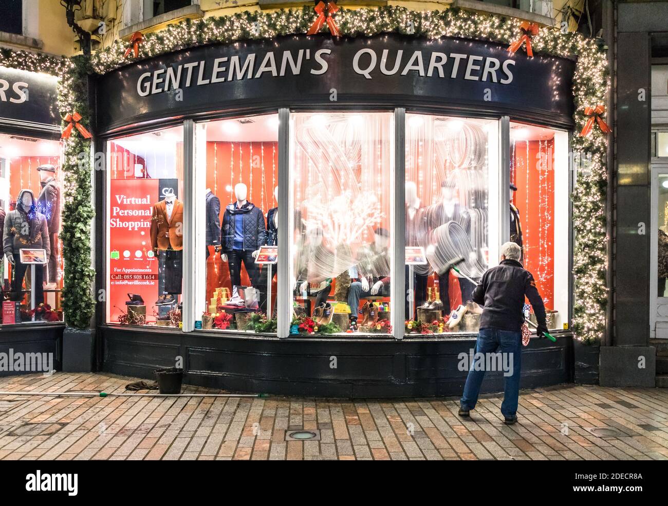 Cork City, Cork, Irland. November 2020. Rory O’Donovan aus Kileens putzt die Fenster des Herrenladens Gentleman’s Quarters in Patrick’s Street, Cork, in Vorbereitung auf die Wiedereröffnung der Geschäfte am 1. Dezember, wenn das Land eine sechswöchige Stufe 5-Sperre beendet. - Credit; David Creedon / Alamy Live News Stockfoto