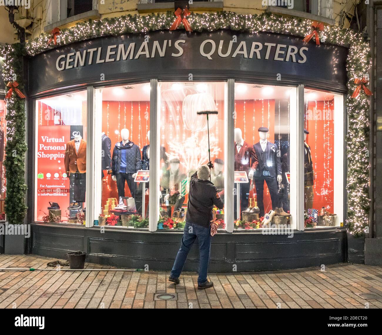 Cork City, Cork, Irland. November 2020. Rory O’Donovan aus Kileens putzt die Fenster des Herrenladens Gentleman’s Quarters in Patrick’s Street, Cork, in Vorbereitung auf die Wiedereröffnung der Geschäfte am 1. Dezember, wenn das Land eine sechswöchige Stufe 5-Sperre beendet. - Credit; David Creedon / Alamy Live News Stockfoto