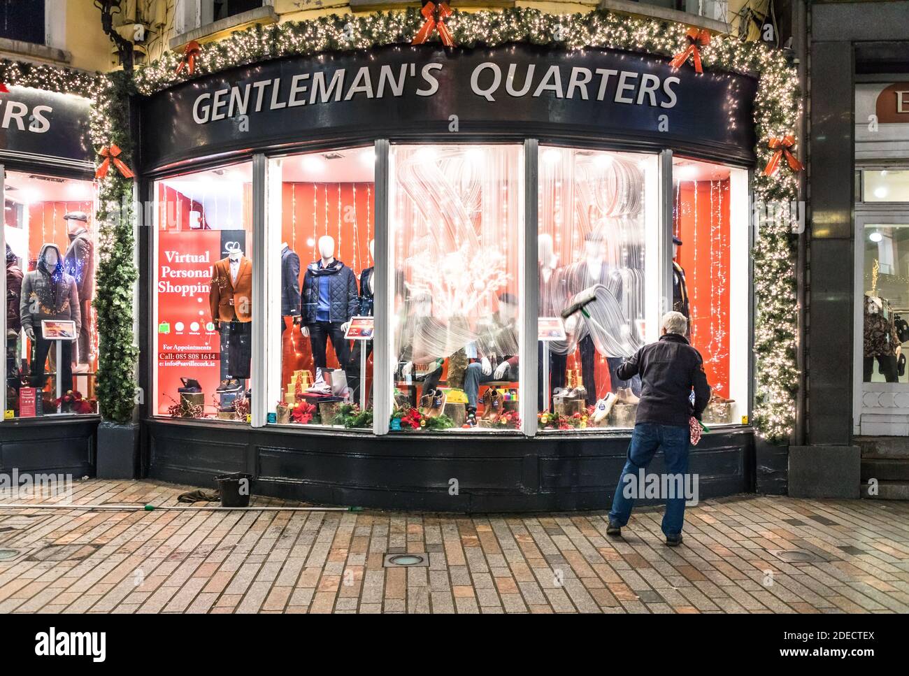 Cork City, Cork, Irland. November 2020. Rory O’Donovan aus Kileens putzt die Fenster des Herrenladens Gentleman’s Quarters in Patrick’s Street, Cork, in Vorbereitung auf die Wiedereröffnung der Geschäfte am 1. Dezember, wenn das Land eine sechswöchige Stufe 5-Sperre beendet. - Credit; David Creedon / Alamy Live News Stockfoto