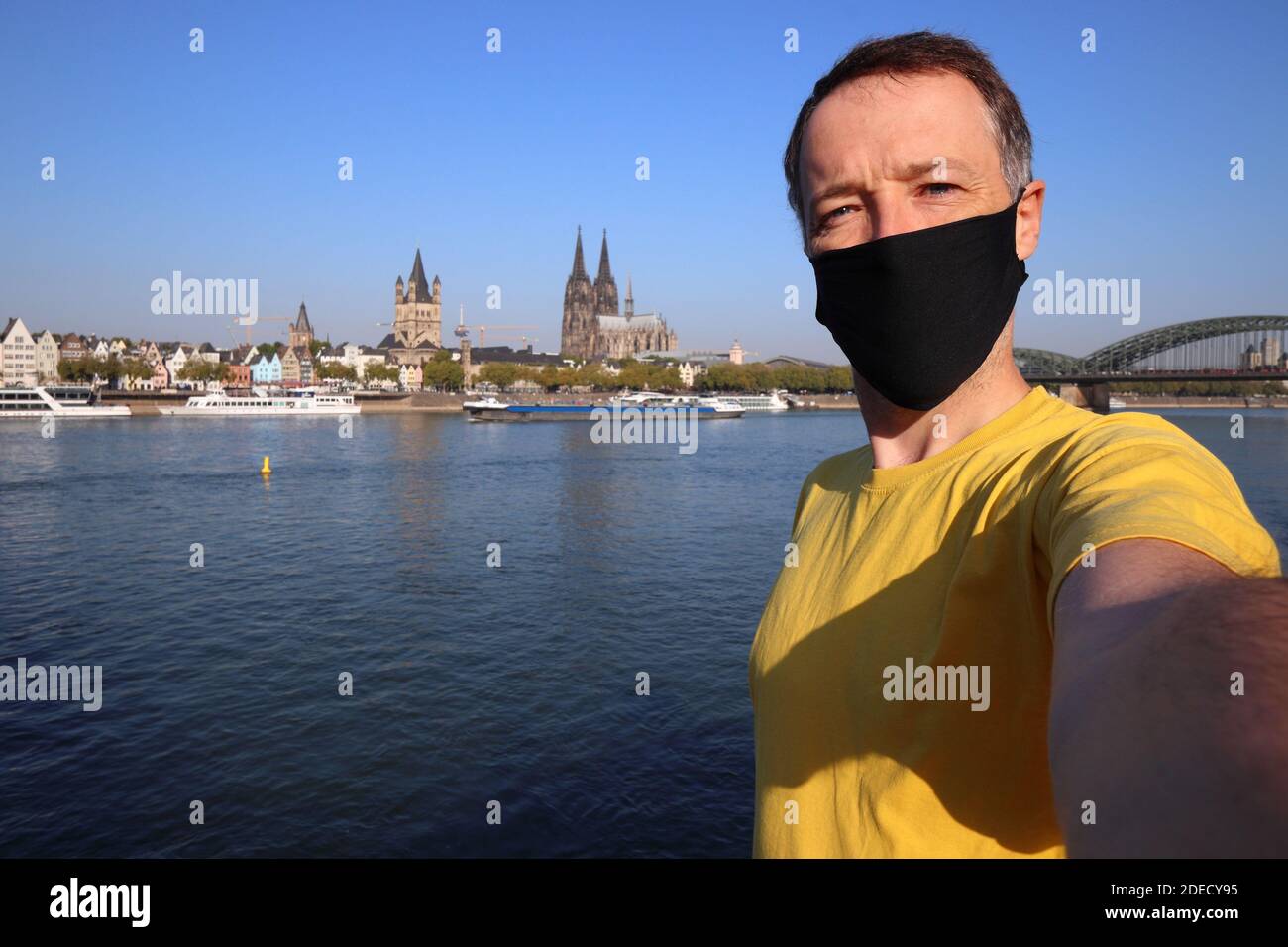 Tourist Selfie mit Gesichtsmaske in Köln, Deutschland. Selfie für Reisende mit Kölner Skyline. Stockfoto