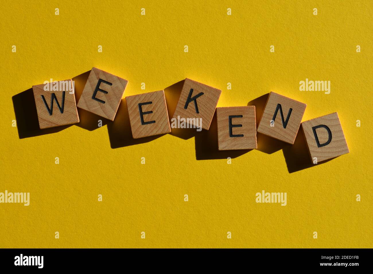 Wochenende, Wort in Holzbuchstaben isoliert auf hellgelben Hintergrund Stockfoto