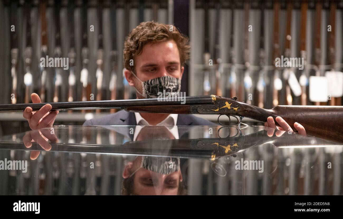 Knightsbridge, London, Großbritannien. November 2020. Vorschau von Bonhams' Antique Arms, Modern Sporting Guns & Exceptional Firearms Verkauf in London. Der Verkauf findet am 3. Dezember statt. Bild: Bonhams-Mitarbeiter mit einer von zwei Ken Hunt dekorierten 12-bore selbstöffnenden Seitenschieberkanonen von J. Purdey & Sons, fertiggestellt 1968. Hunt wurde 1935 geboren und wurde im Alter von 15 Jahren Gravierlehrling bei Purdey's unter dem berühmten Harry Kell. 1963 ging er selbstständig in Betrieb und arbeitete bis zu seiner Pensionierung 2011. Schätzung: £35,000-55,000. Quelle: Malcolm Park/Alamy Live News Stockfoto