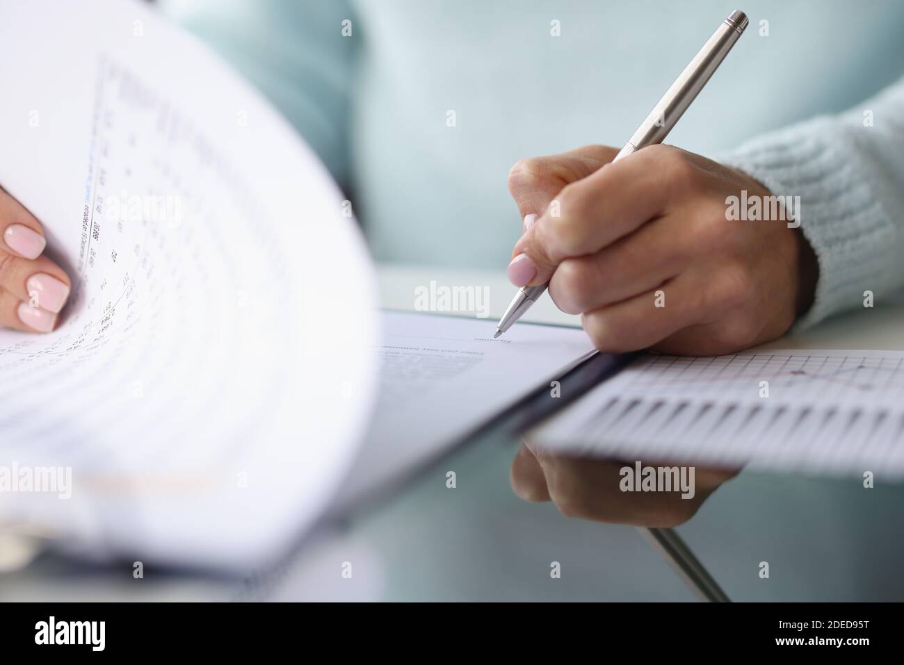 Frau Hand legt Unterschrift auf Dokumente Nahaufnahme Stockfoto