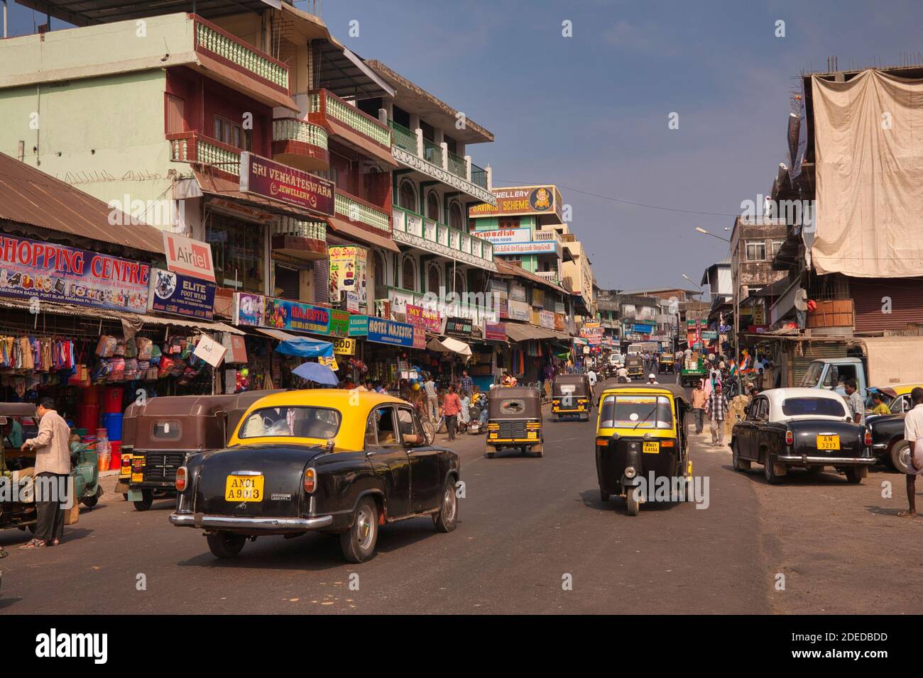 Aktivität in der Hauptstraße von Port Blair auf den Andaman-Inseln mit gelben und schwarzen Taxis und Tri shaw auf der Straße. Stockfoto