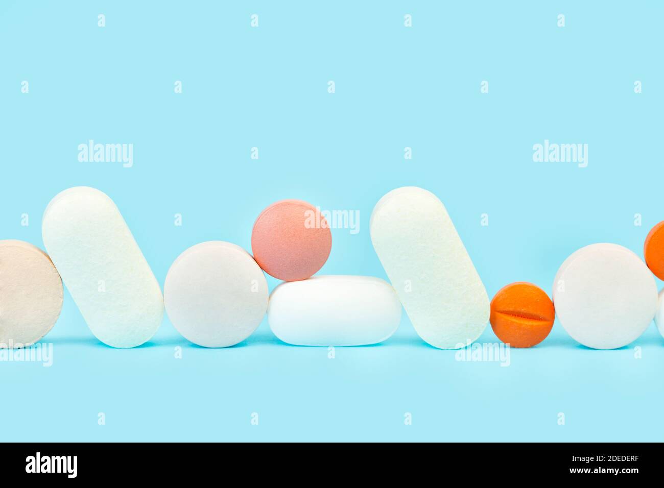 Farbige medizinische Pillen auf einem hellblauen Hintergrund in einem Vorderansicht Stockfoto