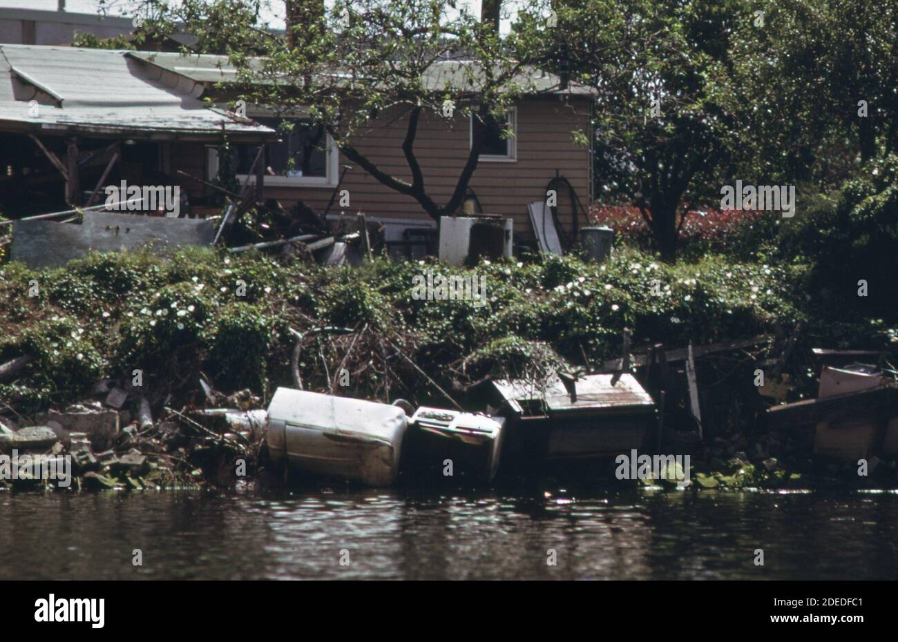 1970-er Foto (1973) - Hausbesitzer am Duwamish-Fluss verwendet weggeworfene Kühlschrank-Waschmaschine, Herd und Beton, um Erosion des Flussufers zu verhindern" Stockfoto