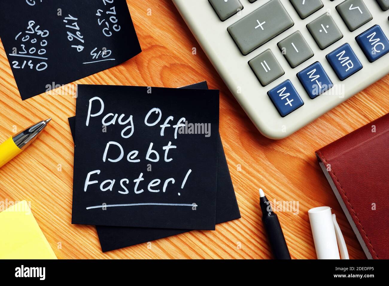 Schulden schneller abzahlen handgeschriebenes Memo und Rechner. Stockfoto