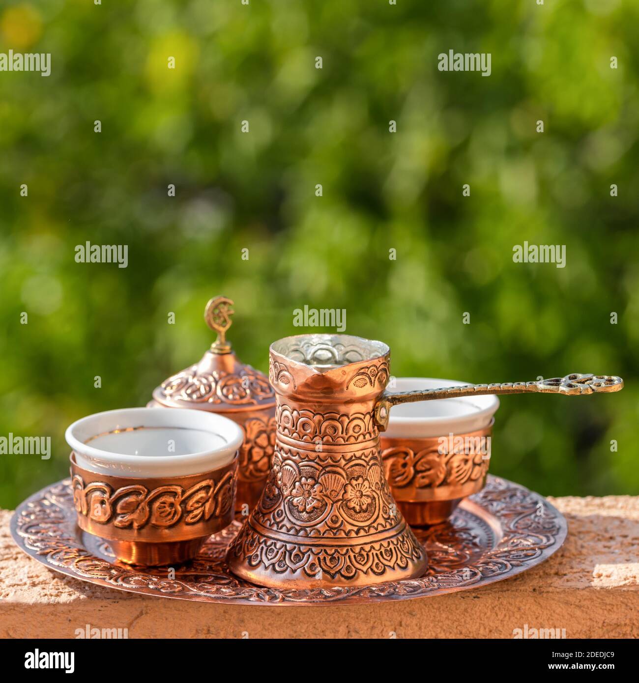 Traditioneller schwarzer bosnischer Kaffee in schöner Kupferkeuze am Holztisch Stockfoto