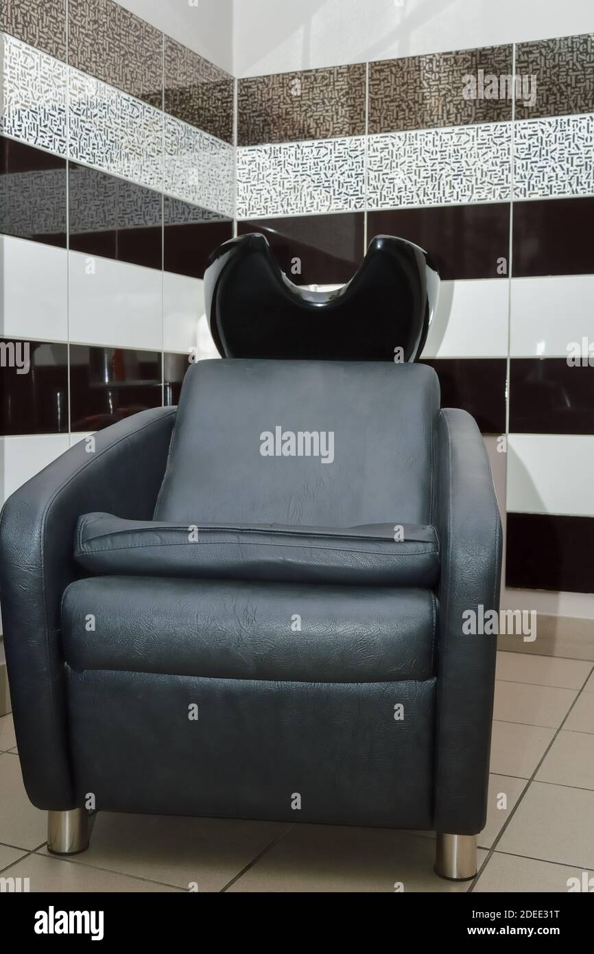 Schwarzer bequemer Luxus-Stuhl zum Haarwaschen im Schönheitssalon Stockfoto
