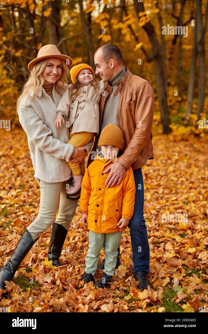 Ganzkörperportrait von lieblichen Familie mit Kindern im Herbst sonnigen Wald, kaukasischen Eltern und Kinder in Mänteln posiert vor der Kamera Stockfoto Ganzkörperportrait von lieblichen Familie mit Kindern im Herbst sonnigen Wald, kaukasischen Eltern und Kinder in Mänteln posiert vor der Kamera Stockfoto
