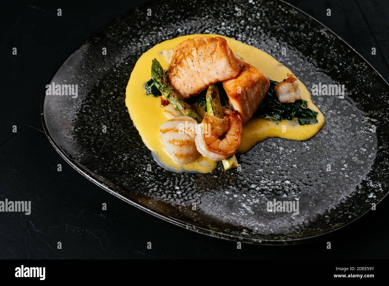 Gegrillter Lachs und Garnelen auf schwarzem Hintergrund Stockfoto