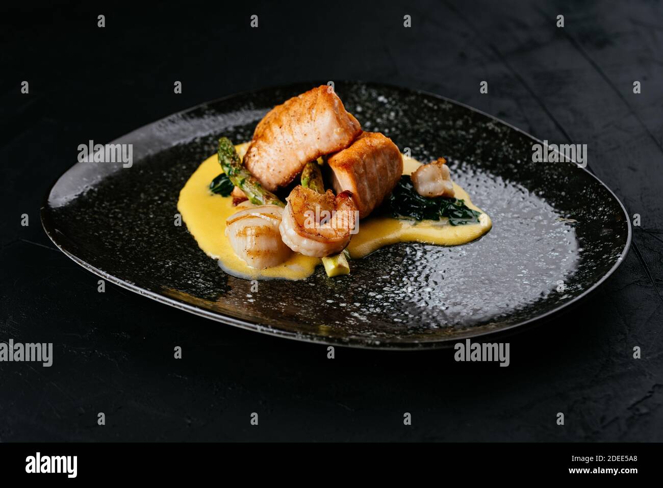 Gegrillter Lachs und Garnelen auf schwarzem Hintergrund Stockfoto
