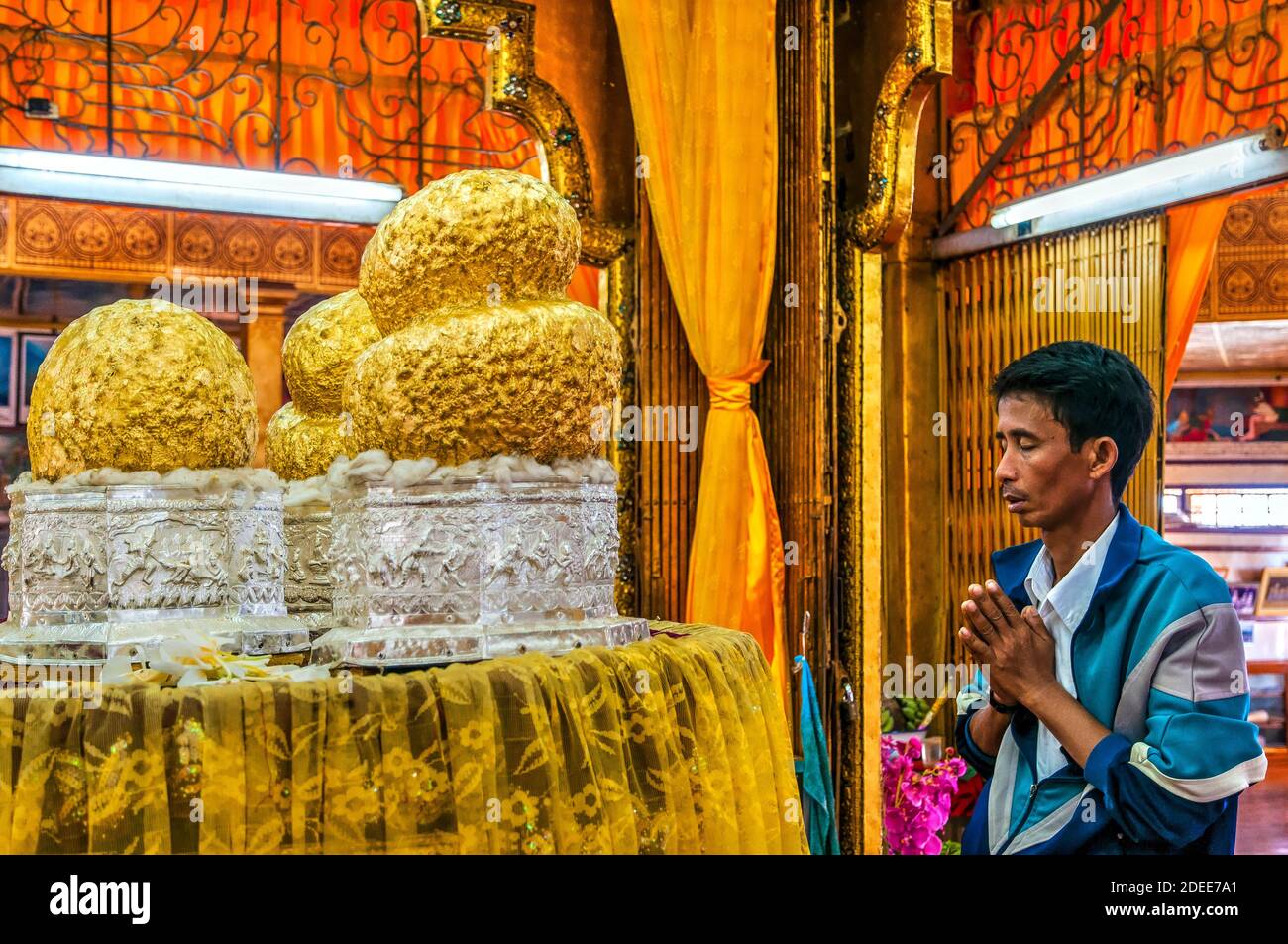 Mann betet vor vier kleinen Buddhas, die mit Gold bedeckt sind, Phaung Daw Oo Paya Pagode, Inle Lake, Myanmar Stockfoto