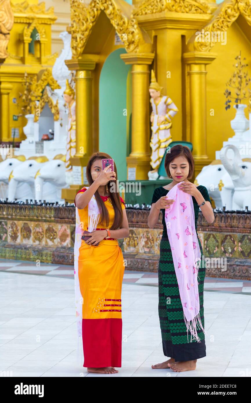 Hübsche junge Touristen mit Thanaka auf den Wangen, die im Februar Fotos in der Shwedagon Pagode, Yangon, Myanmar (Burma), Asien machen Stockfoto