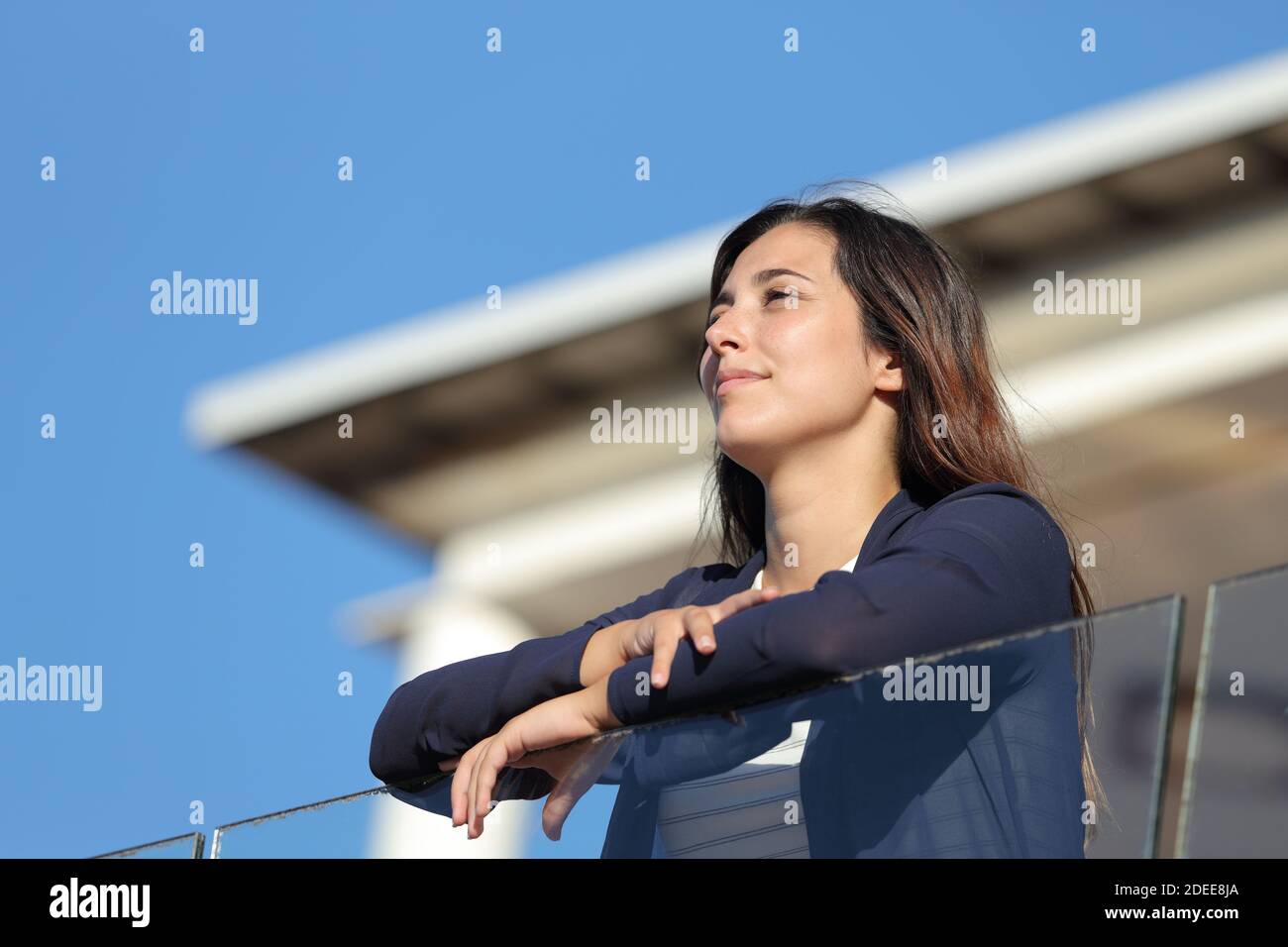 Zufriedene Frau, die Aussicht vom Balkon der Wohnung einen sonnigen Tag Stockfoto