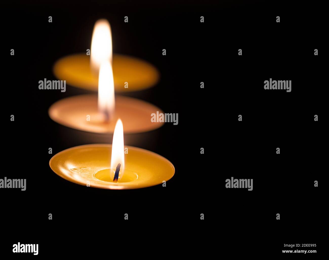 Drei Teelichter vor schwarzem Hintergrund Stockfoto