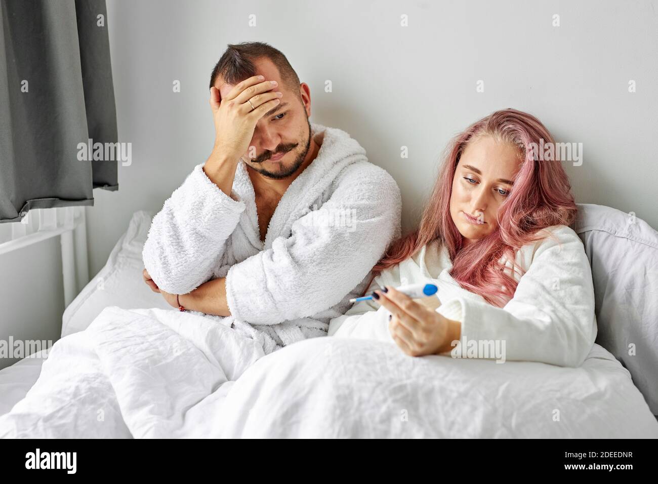 Unglückliches Paar fand heraus über Schwangerschaft, liegen auf dem Bett am Morgen, Blick auf Test, unzufrieden mit ungeplanten, unerwünschten Schwangerschaft Stockfoto