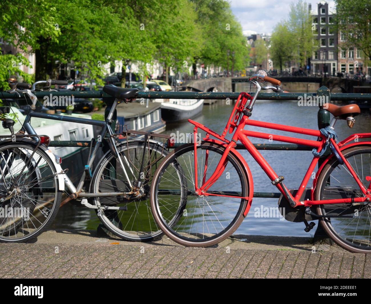AMSTERDAM, NIEDERLANDE - 01. MAI 2018: Geparkte Fahrräder auf einer Brücke über die Brouwersgracht mit Blick auf den Kanal im Hintergrund Stockfoto
