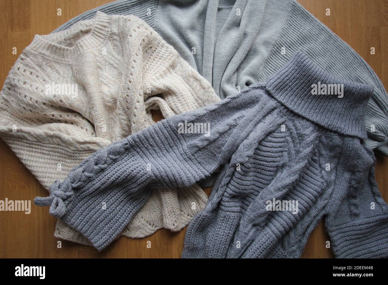 Drei Pastell-Pullover für den Winter. Modische Damenbekleidung. Kuscheliger Winter-Look. Flach liegend, Draufsicht. Stockfoto