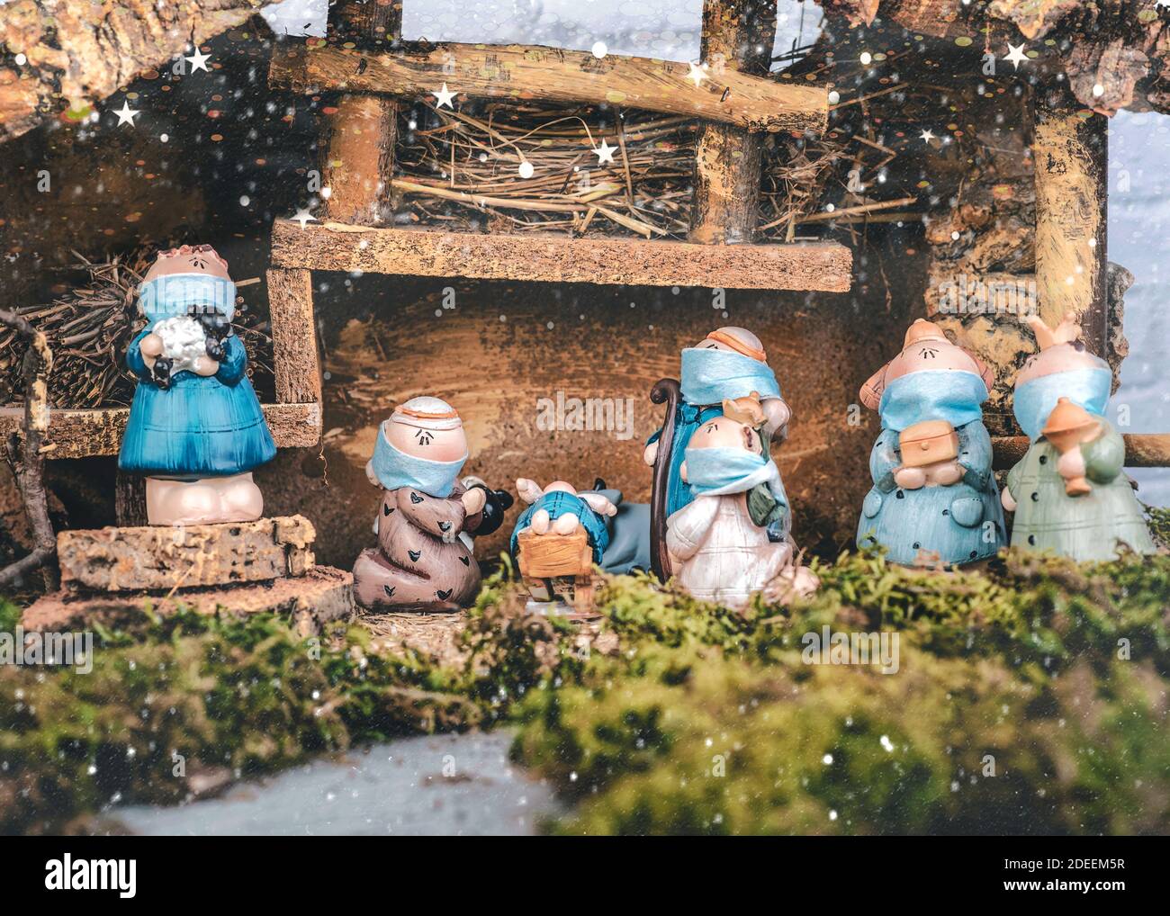 Weihnachtskrippe. Krippe Statuen Figuren mit schützenden chirurgischen Masken.Szene des geborenen Kindes Baby Jesus.Weihnachtskonzept Hintergrund Stockfoto