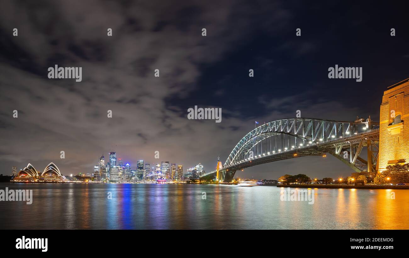 Sydney, New South Wales, Australien; Skyline von Sydney und Opernhaus bei Nacht beleuchtet. Stockfoto