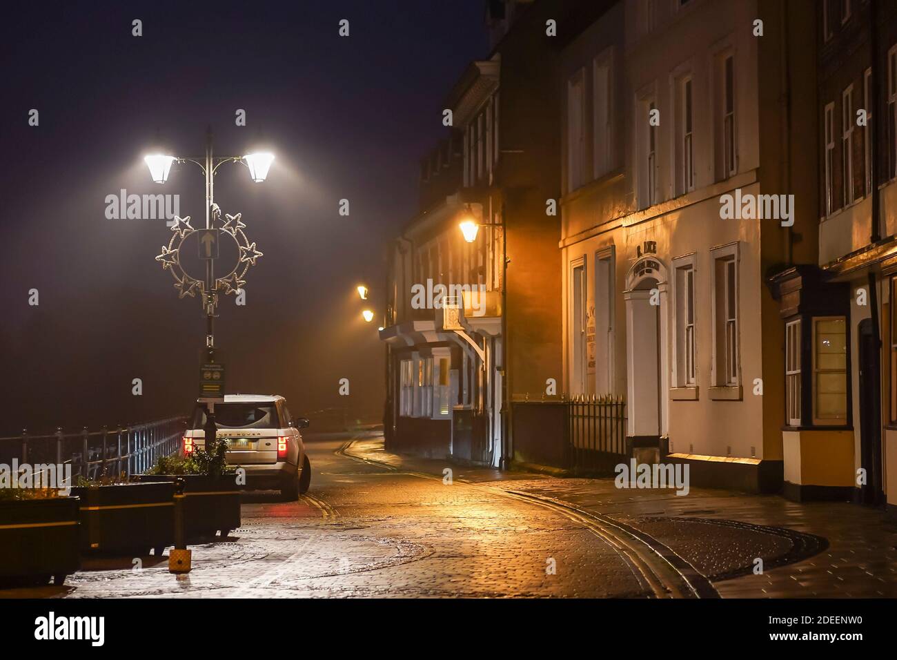 Range Rover geparkt unter einer Straßenlaterne in der Nacht in einem Straße der Häuser Stockfoto