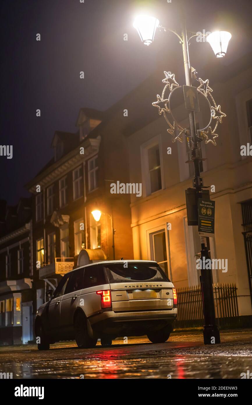 Range Rover geparkt unter einer Straßenlaterne in der Nacht in einem Straße der Häuser Stockfoto