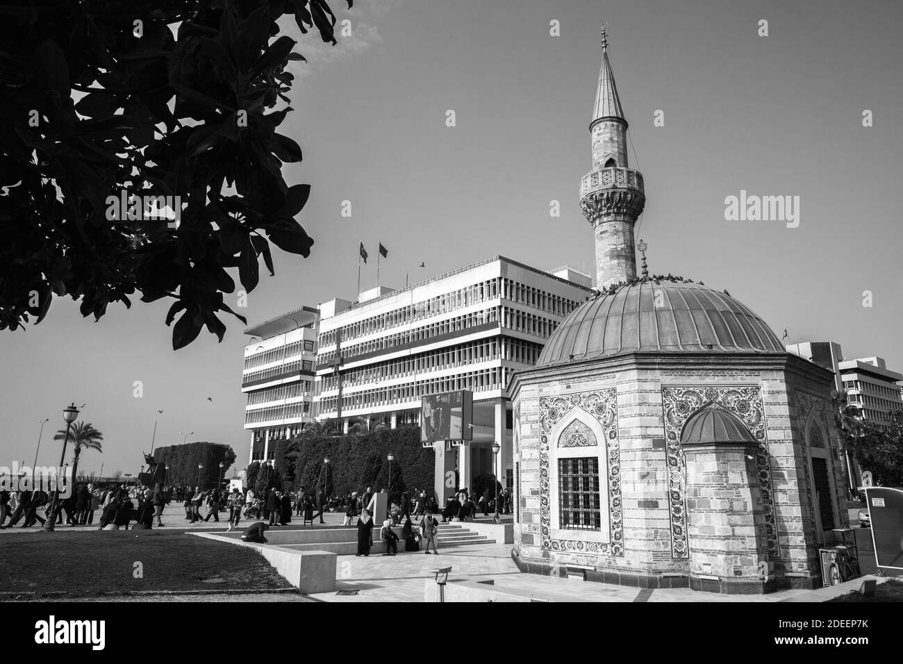 Izmir, Türkei - 5. Februar 2015: Blick auf den Konak-Platz mit der alten Camii-Moschee, gewöhnliche Menschen gehen die Straße entlang. Schwarzweiß-Foto. Stockfoto
