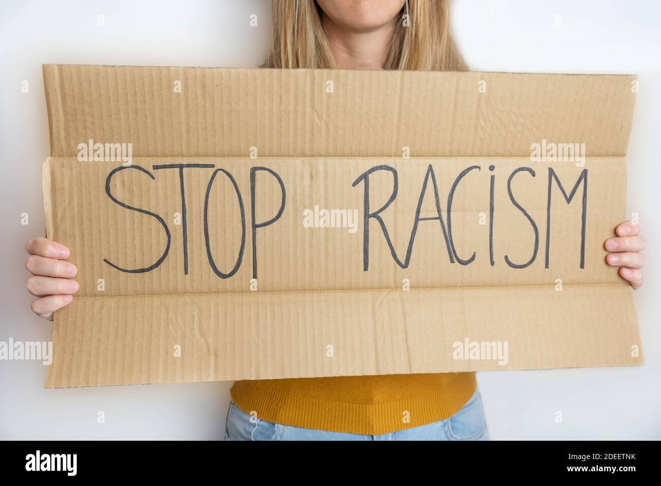 Junge schöne Frau hält ein Protestplakat mit dem Text Stop Rassismus Politik und soziale Probleme Konzept, Anti-Rassendiskriminierung Lebensstil. Stockfoto
