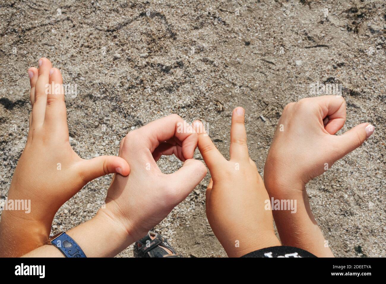 Wortliebe aus Kinderhände, auf Sandhintergrund Stockfoto