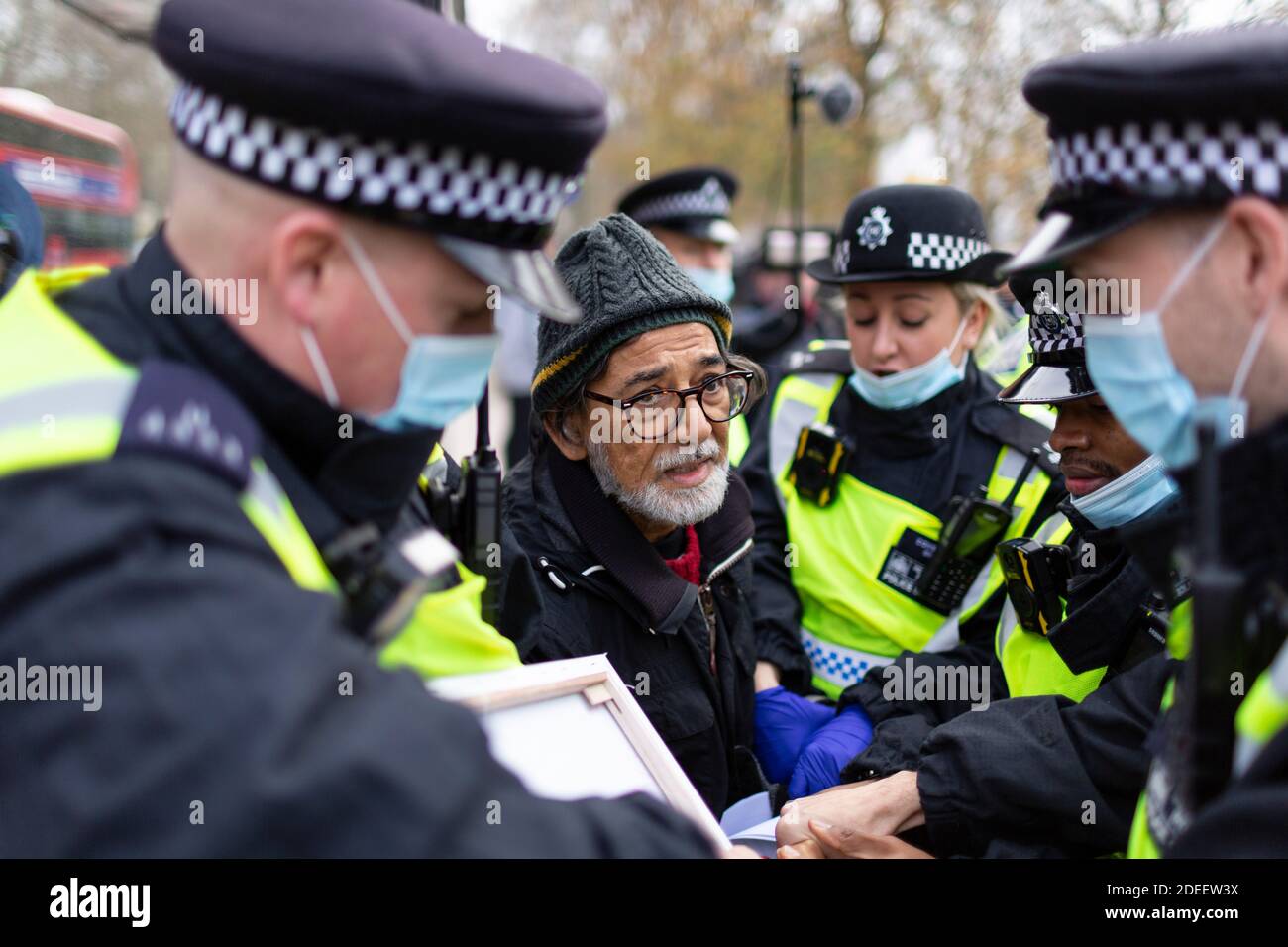 Anti-Lockdown Protest, Hyde Park, London, 28. November 2020. Ein verhafteter älterer Protestler wird von Polizisten in Gesichtsmasken weggeführt. Stockfoto