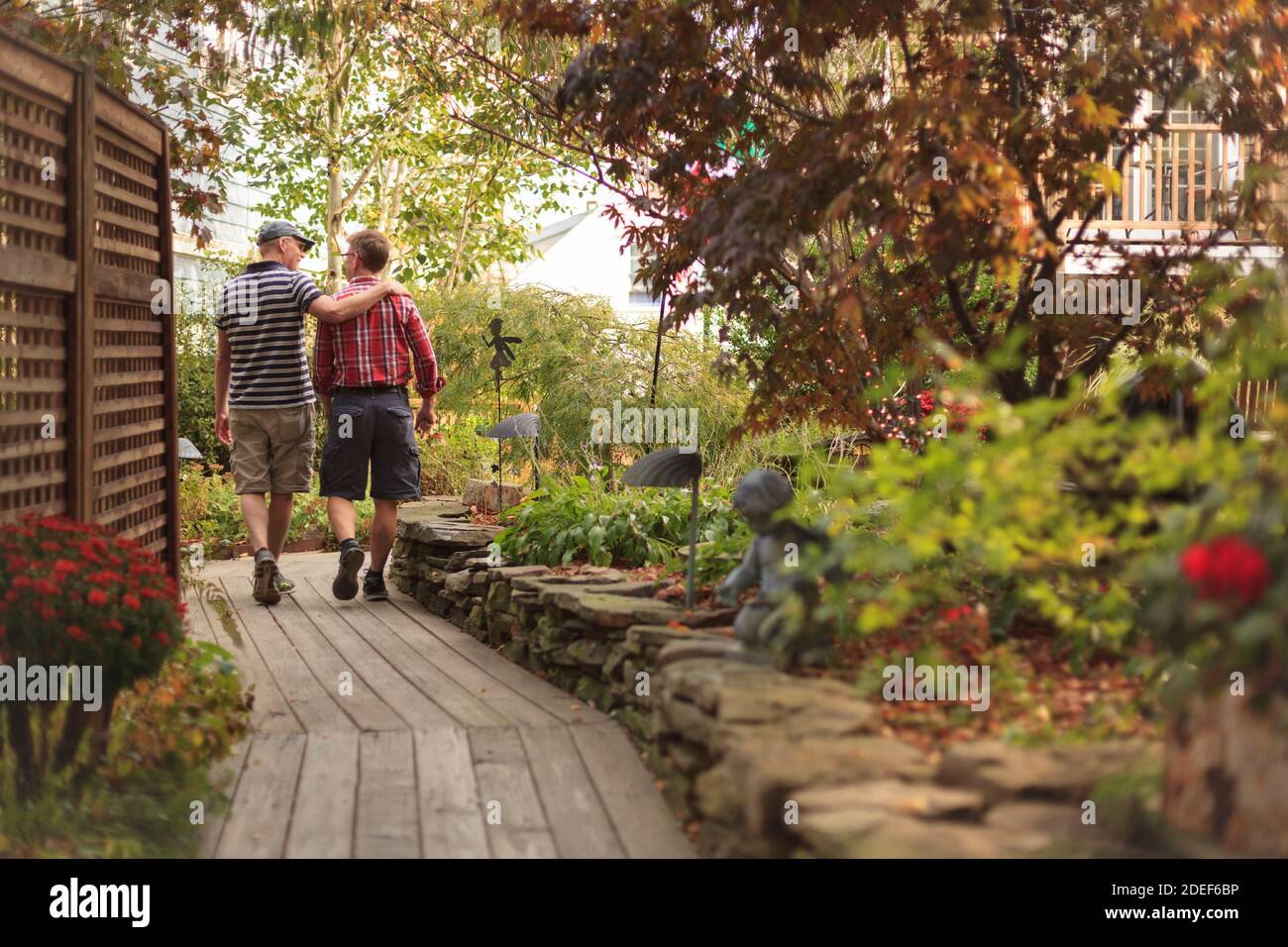 Homosexuell Paar zu Fuß durch einen Garten Stockfoto