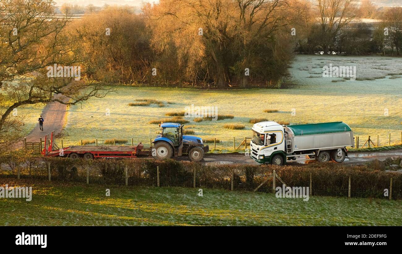 November 2020 - Traktor mit Anhänger und LKW draußen an einem frostigen Morgen im ländlichen Somerset bei Cheddar, Stockfoto