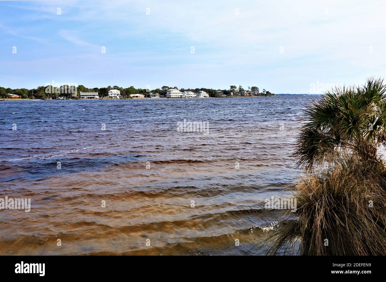 Eine schöne Aussicht auf das Festland von der gegenüberliegenden Küste des Golfs von Mexiko, von Santa Rose Island, das blaue Wasser des Ozeans glänzen mit dem bräunlichen Stockfoto