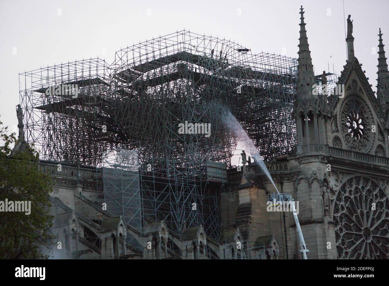 Feuerwehrleute arbeiten, um ein Feuer am Morgen und Sonnenaufgang in der Kathedrale Notre-Dame in Paris am 16. April 2019 zu löschen. Ein gewaltiges Feuer, das die Kathedrale Notre-Dame verwüstet hat, ist "unter Kontrolle", sagte die Pariser Feuerwehr Anfang April 16, nachdem die Feuerwehrleute stundenlang gegen die Flammen gekämpft hatten. Foto von Raphael Lafargue/ABACAPRESS.COM Stockfoto