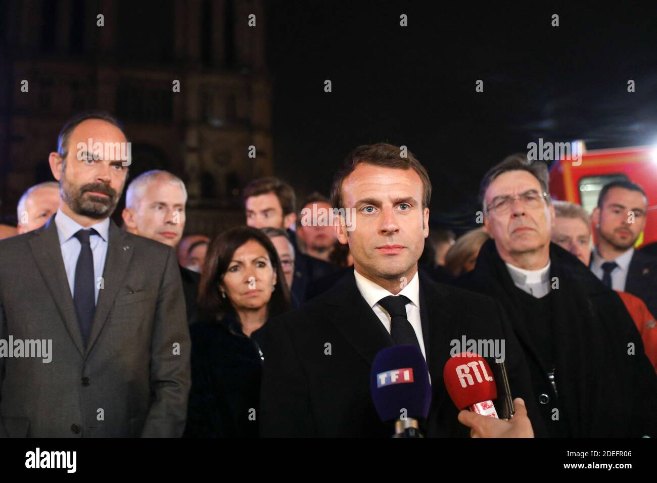 Der französische Präsident Emmanuel Macron wird von der Pariser Bürgermeisterin Anne Hidalgo, dem französischen Premierminister Edouard Philippe, dem französischen Kulturminister Franck Riester und dem Erzbischof von Paris Michel Aupetit begleitet, während er am 15. April 2019 in der Kathedrale Notre-Dame in Paris spricht, nachdem das Gebäude von einem Brand erfasst wurde. In der berühmten Kathedrale Notre-Dame im Zentrum von Paris brach ein Feuer aus, das möglicherweise Renovierungsarbeiten an diesem Ort zur Folge hatte, teilte die Feuerwehr mit.die Bilder, die in den sozialen Medien veröffentlicht wurden, zeigten Flammen und riesige Rauchwolken, die über dem Dach der am meisten besuchten gotischen Kathedrale wölben Stockfoto