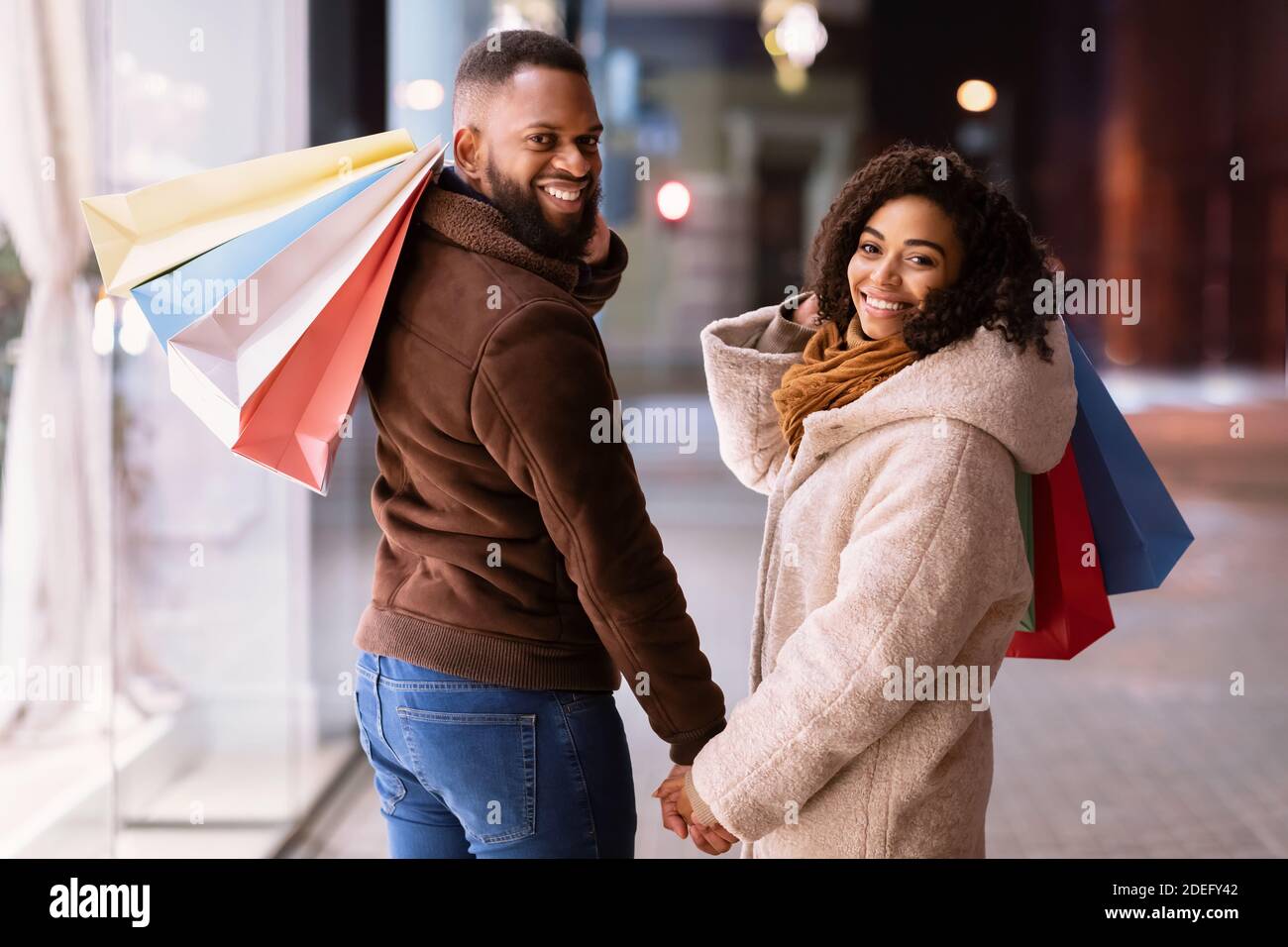 Portrait von glücklichen schwarzen Paar, das sich mit Einkaufstaschen zurückkehrt Stockfoto