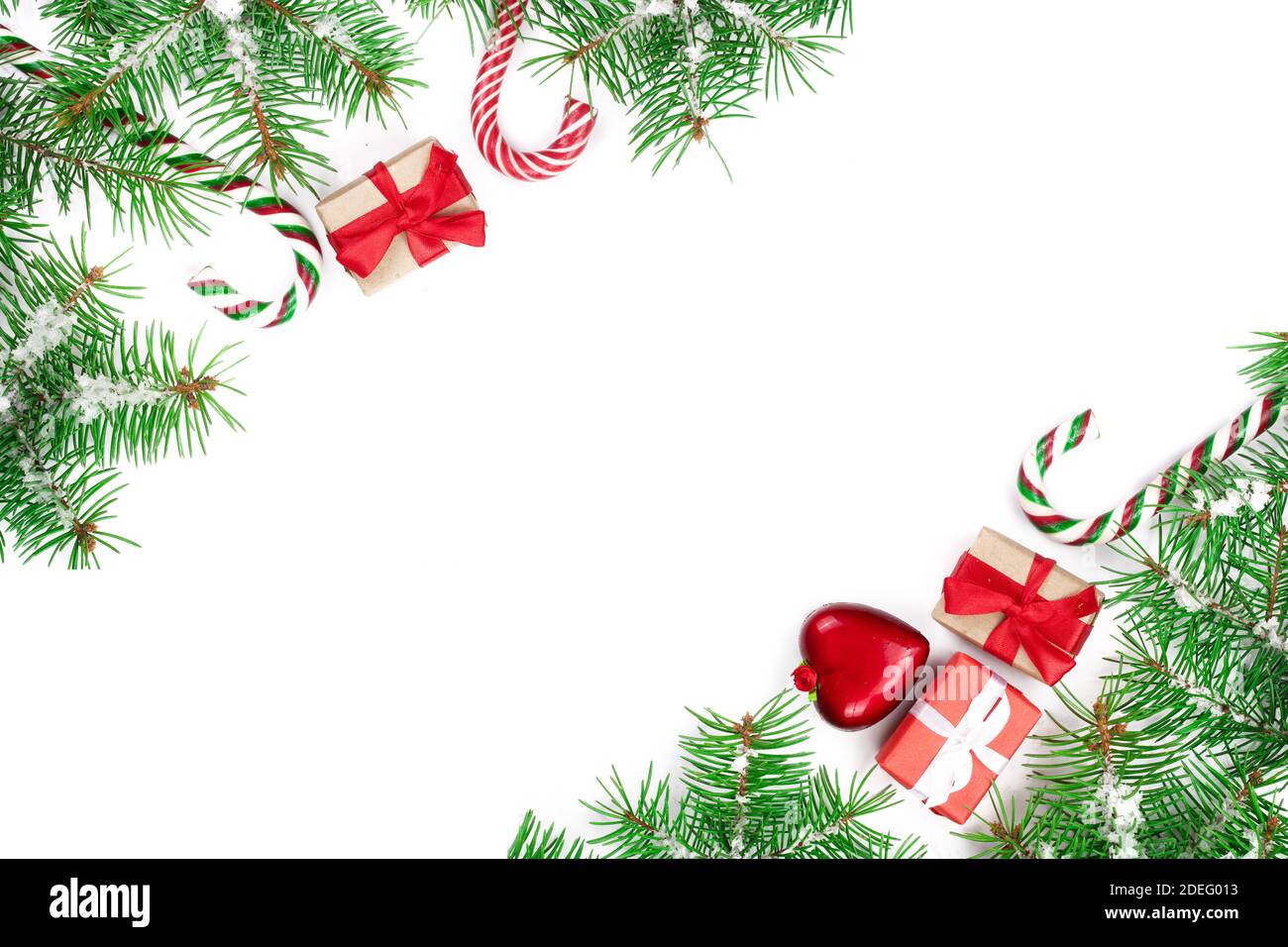 Weihnachten Rahmen der Fir Tree Branch mit Zuckerstangen und Schnee auf weißem Hintergrund mit Kopie Platz für Ihren Text isoliert. Ansicht von oben. Stockfoto