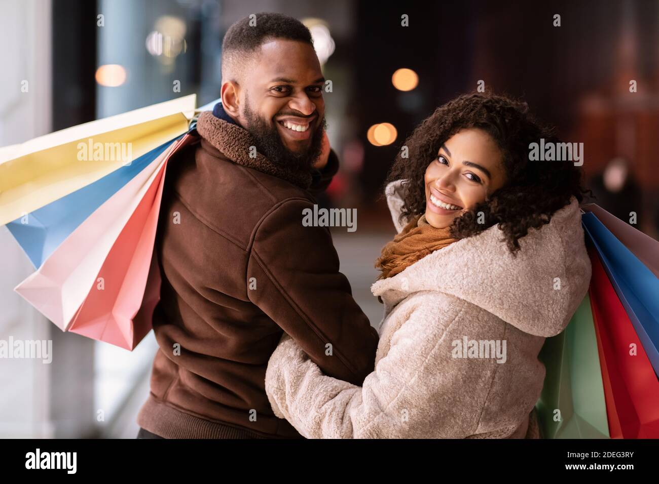 Portrait von glücklichen schwarzen Paar zurückblickend mit Einkaufstaschen Stockfoto