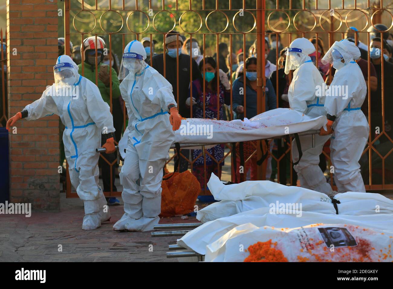 Weibliche Soldaten tragen persönliche Schutzausrüstung (PSA) heben eine Bahre mit dem Körper eines Coronavirus-Opfers, während Familienmitglieder inmitten der Ausbreitung der Coronavirus-Krankheit (COVID-19) in Kathmandu, Nepal, am 11. November 2020 in einem Krematorium trauern. Bild aufgenommen am 11. November 2020. REUTERS/Navesh Chitrakar Stockfoto
