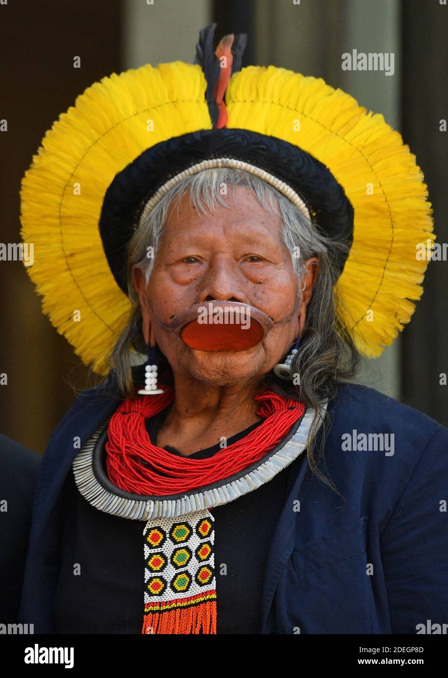 Brasiliens legendärer indigener Chef Raoni Metuktyre (C) posiert am 16. Mai 2019 in Paris vor den Toren des Präsidentenpalastes Elysee, als sie zu einem Treffen mit dem französischen Präsidenten eintreffen, Teil einer dreiwöchigen Tour durch Europa, bei der sie Staatsoberhäupter treffen werden. Prominente und der Papst zu den wachsenden Bedrohungen für den Amazonas zu markieren. Der ältere Kayapo-Chef, international bekannt durch seine traditionelle Lippenplatte und Federkopfschmuck, wird versuchen, eine Million Euro (0,1 Million) zu sammeln, um das Amazonas-Xingu-Reservat, Heimat vieler brasilianischer Stammesvölker, besser vor Holzfällern zu schützen, f Stockfoto